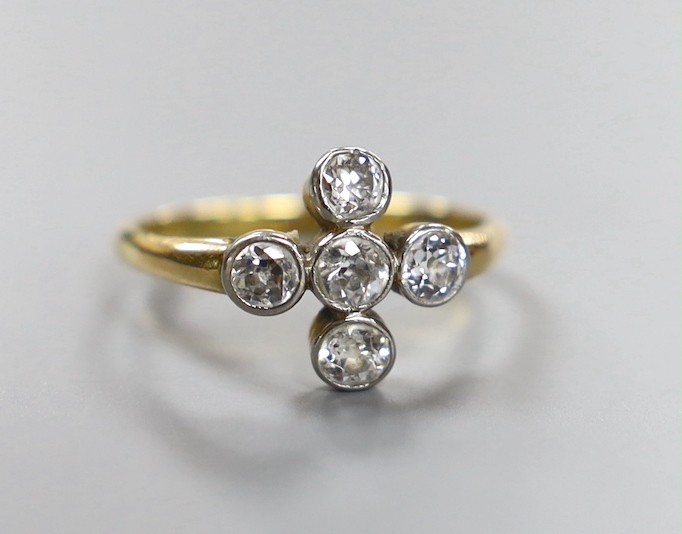An 18ct and collet set five stone diamond 'cross' ring, size O, gross weight 3 grams.
